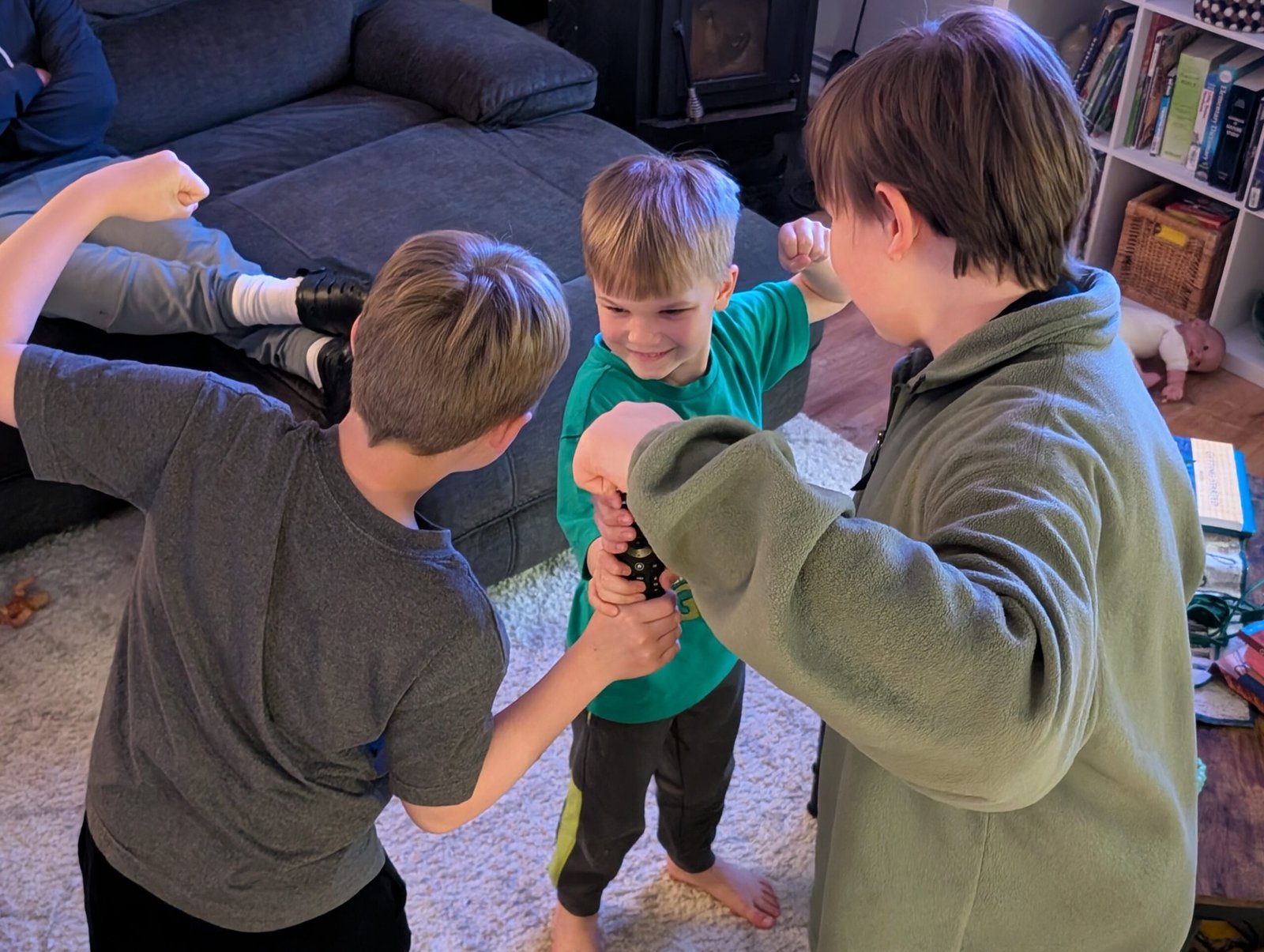 Our New Series on Faith-Friendly Streaming Picks for Busy Families Three boys playfully fighting over the remote control, capturing the fun chaos of family movie night decisions.