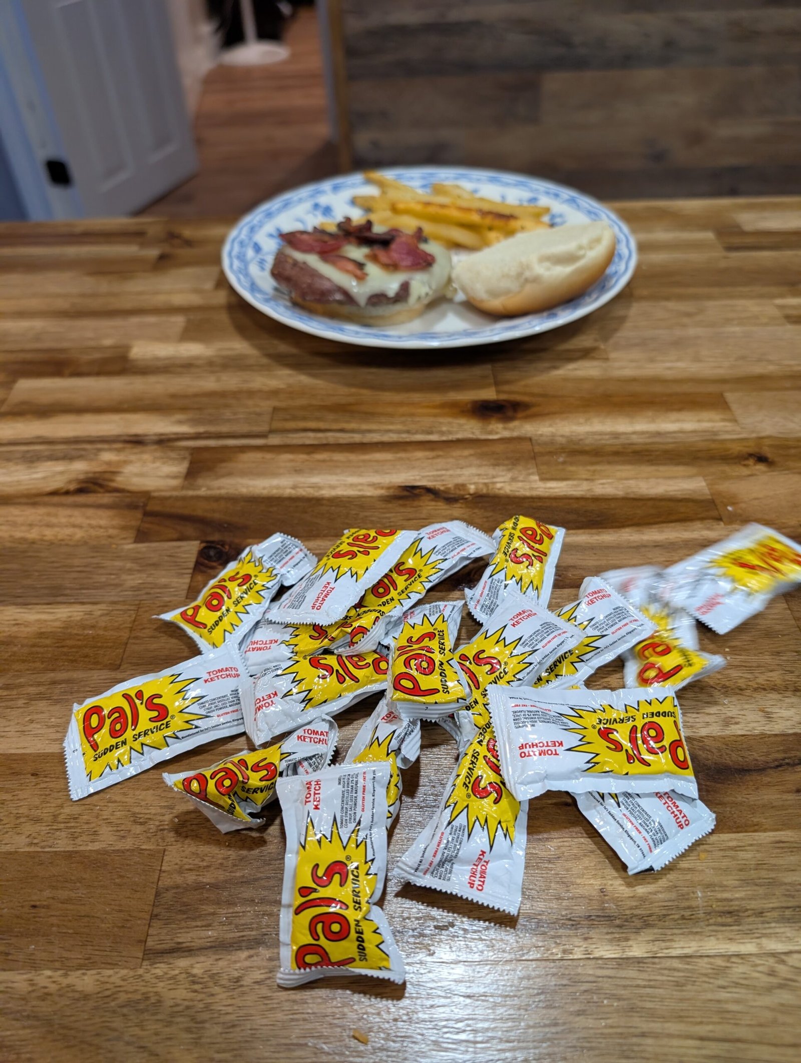 Ketchup Packets and God's Gentle "Not Yet": A Tennessee Memory That Found Its Way Back to Our Dinner Table A handful of Pals ketchup packets on our kitchen island, with a plate of homemade burgers and fries in the background.